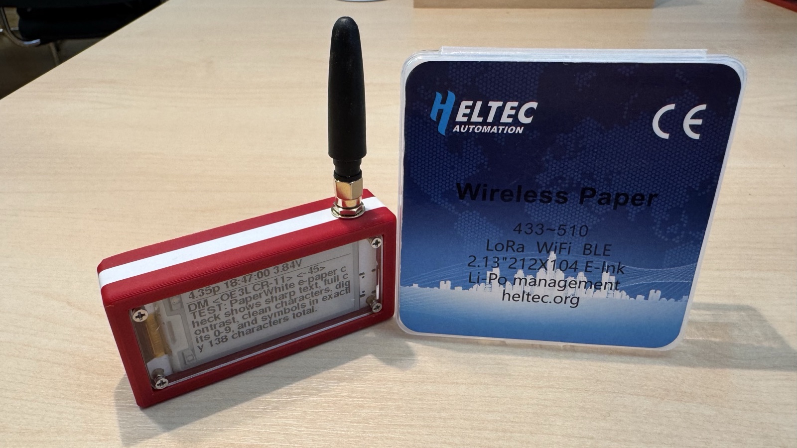 Kompakter MeshCom-Node mit Antenne neben der Verpackung